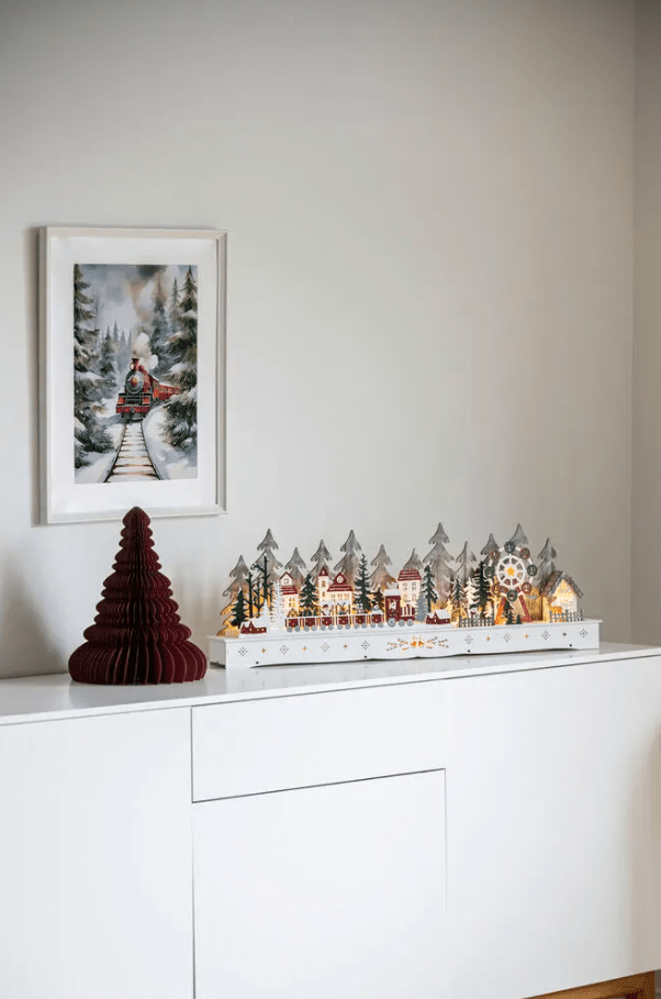 Nisseby LED 25cm Flerfarget Fra Konstsmide - Santa Village er utstyrt med en timer for 6 timer drevet av 2 AA-batterier (ikke inkludert).