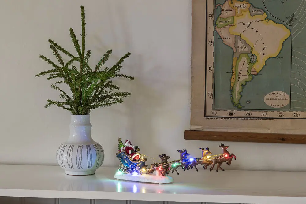 Nisse Med Reinsdyr 14cm Flerfarget Fra Konstsmide - Elegant juledekorasjon med nissen i slede og reinsdyr, opplyst av fargerike LED-lys.