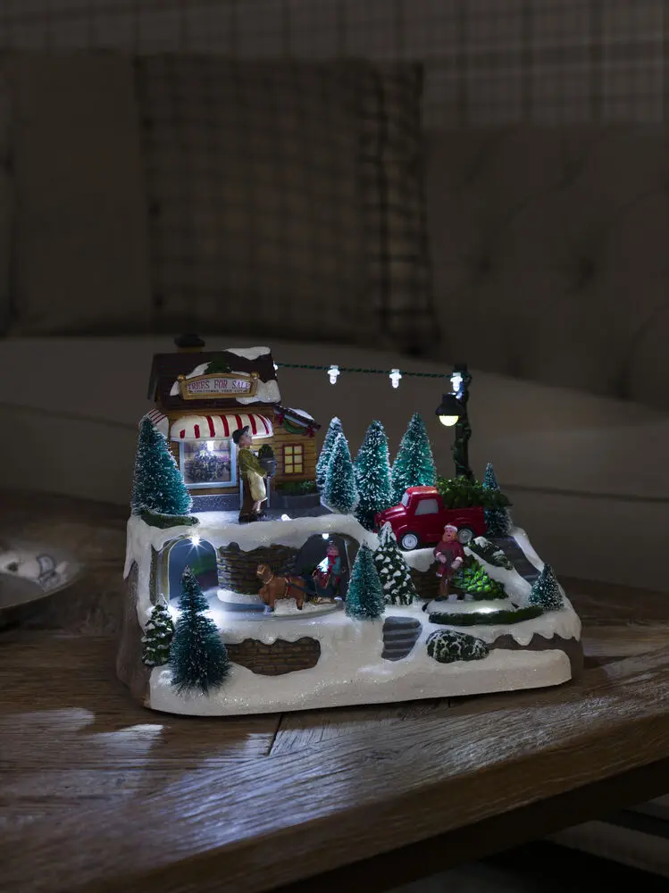 Mekanisk Juledekorasjon Med Juletresalg 17cm Flerfarget Fra Konstsmide - Skap en livlig julestemning med denne mekaniske juledekorasjonen &ndash; en sjarmerende scene med juletr&aelig;r i vinterdrakt.