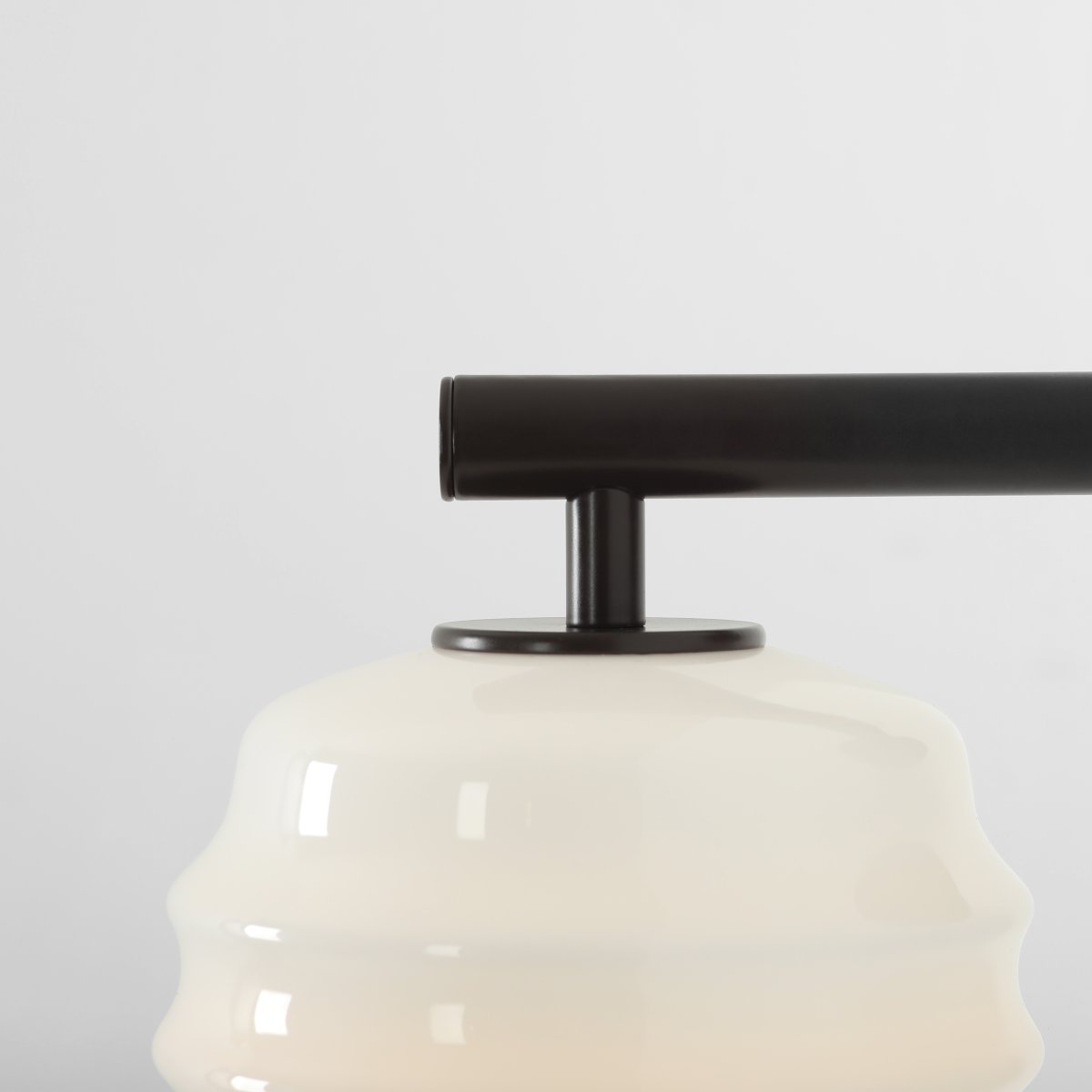 Puff 23cm Mørk brun vegglampe Fra Artera - Den dekorative skjermen i hvitt opalglass har en bølget form som gir lampen et lekent og elegant uttrykk.