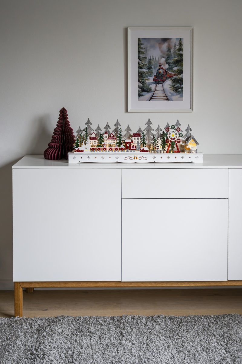 Nisseby LED 25cm Flerfarget Fra Konstsmide - Santa Village er utstyrt med en timer for 6 timer drevet av 2 AA-batterier (ikke inkludert).