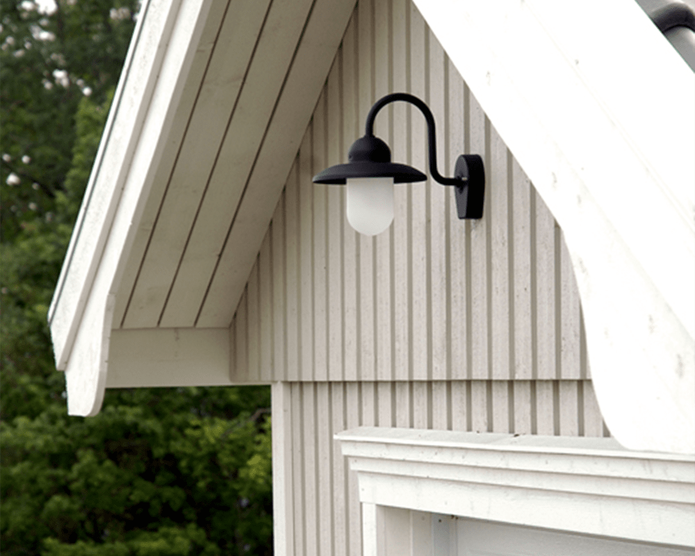 Nisse Svart utendørslampe Fra Westal - Nisee er en klassisk vegglampe for utendørs bruk som kombinerer tidløs design med materialer av høy kvalitet.