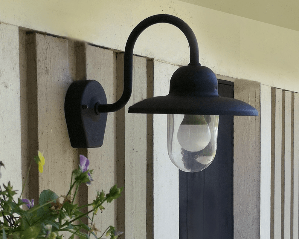Nisse Svart utendørslampe Fra Westal - Nisee er en klassisk vegglampe for utendørs bruk som kombinerer tidløs design med materialer av høy kvalitet.
