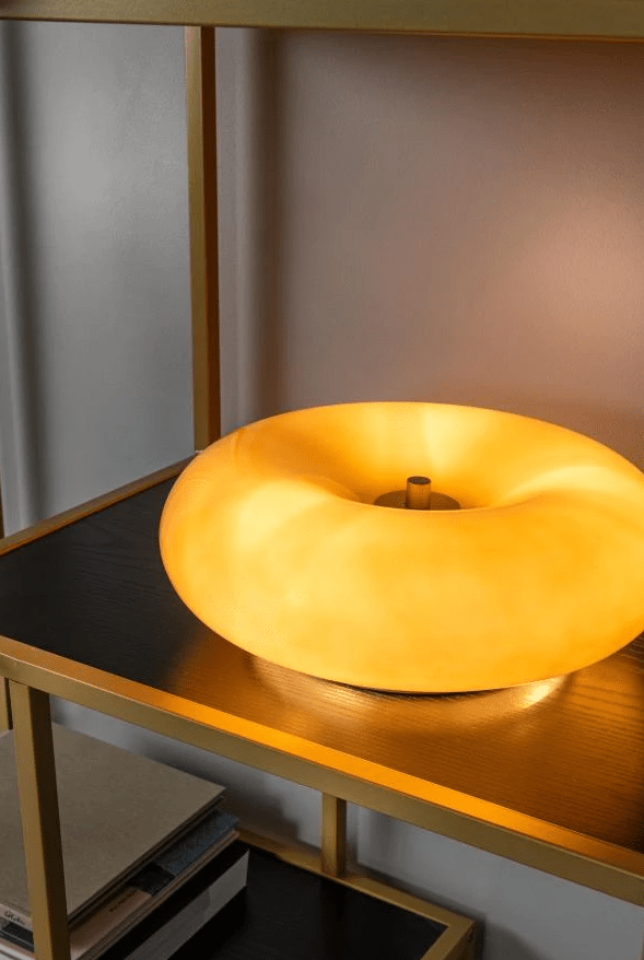 Sentino 10cm Taupe bordlampe Fra Lucide - Denne unike bordlampen kombinerer et blankt lakkert glasshus i smultringform med en elegant metallbase – et stiluttrykk som både tiltrekker seg oppmerksomhet og løfter helhetsinntrykket i rommet.