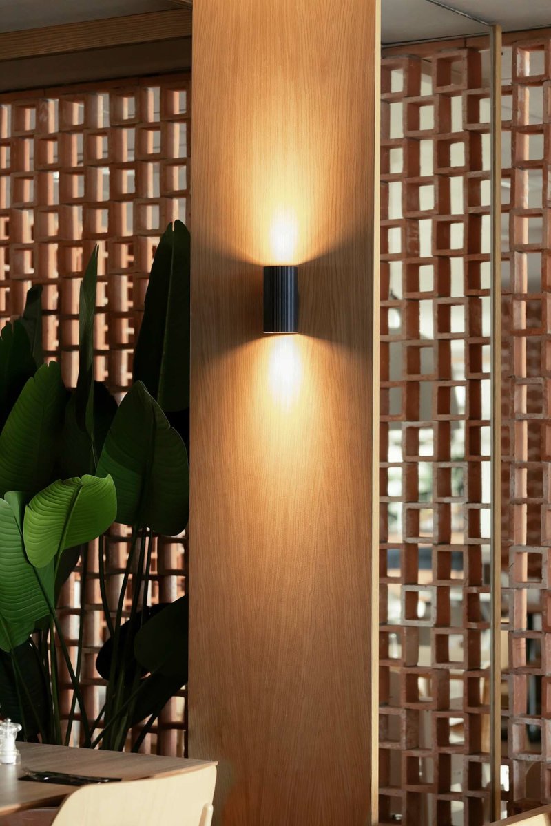 Sole 15cm Svart rillet vegglampe Fra Faro Barcelona - Den er tilgjengelig i to st&oslash;rrelser og kan avgi lys i &eacute;n eller to retninger, noe som gj&oslash;r den ideell for ganger og mindre rom.