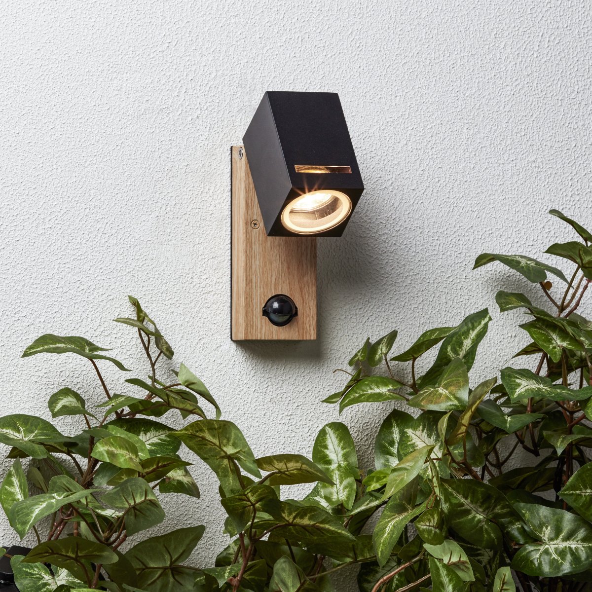 Galeni Natur utendørslampe Fra Brilliant - Den har en justerbar spotlight og en innebygd bevegelsessensor som kan justeres i følsomhet, lys og tid, noe som gjør den både funksjonell og praktisk.