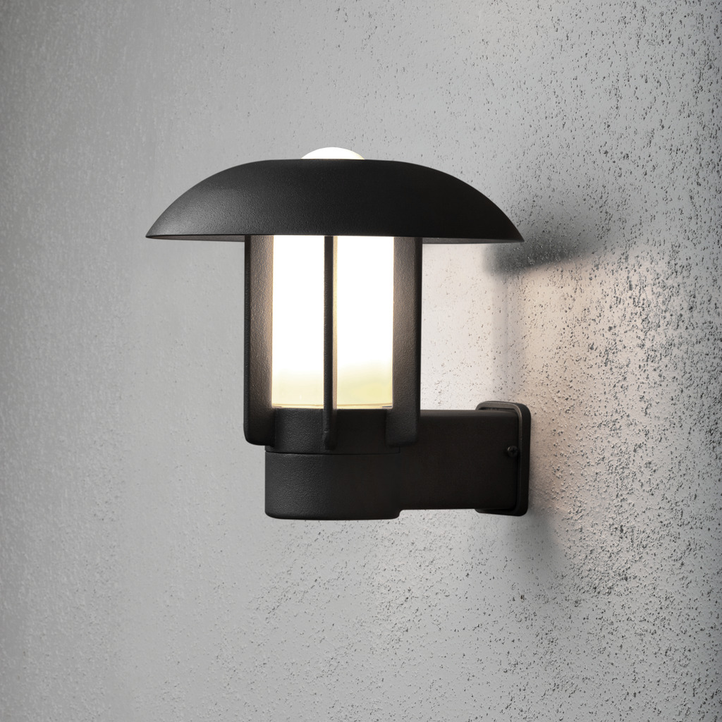 Heimdal Svart utendørslampe Fra Konstsmide - Dens robuste konstruksjon og kuppelformede tak skaper et behagelig, nedoverrettet lys som er ideelt for innganger, ganger og uteplasser.