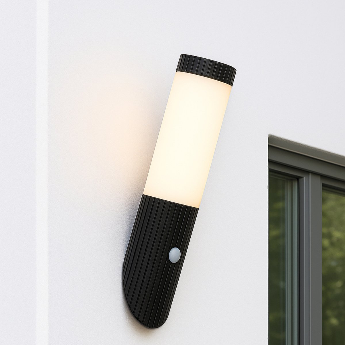 Cassio Svart utendørslampe Fra Brilliant - Lampen er utstyrt med en integrert bevegelsessensor som automatisk aktiverer belysningen når det er bevegelse – en ideell løsning for inngangspartier, innkjørsler eller hagestier der sikkerhet og komfort er viktig.