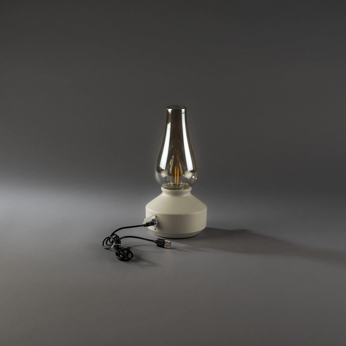 Oppladbar bordlampe 25cm Hvit bærbar Fra Konstsmide - Lampen er laget av metall og glass med en hvit lampefot og en praktisk dimmer som gjør det enkelt å justere det varmhvite, atmosfæriske lyset.