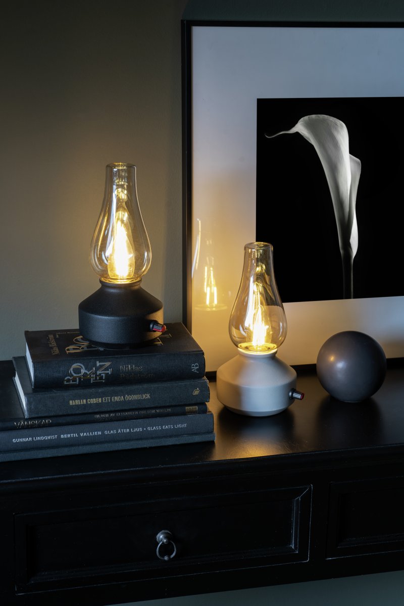 Oppladbar bordlampe 25cm Hvit bærbar Fra Konstsmide - Lampen er laget av metall og glass med en hvit lampefot og en praktisk dimmer som gjør det enkelt å justere det varmhvite, atmosfæriske lyset.