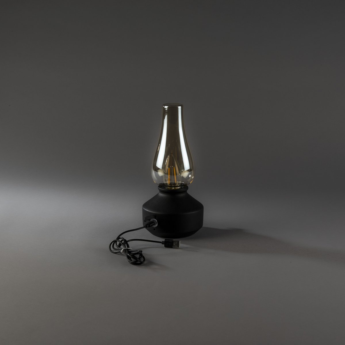 Oppladbar bordlampe 25cm Svart bærbar Fra Konstsmide - Lampen er laget av metall og glass med en svart lampefot og en praktisk dimmer som gjør det enkelt å justere det varmhvite, atmosfæriske lyset.