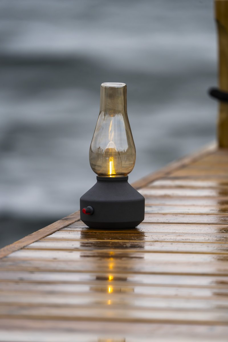 Oppladbar bordlampe 25cm Svart bærbar Fra Konstsmide - Lampen er laget av metall og glass med en svart lampefot og en praktisk dimmer som gjør det enkelt å justere det varmhvite, atmosfæriske lyset.
