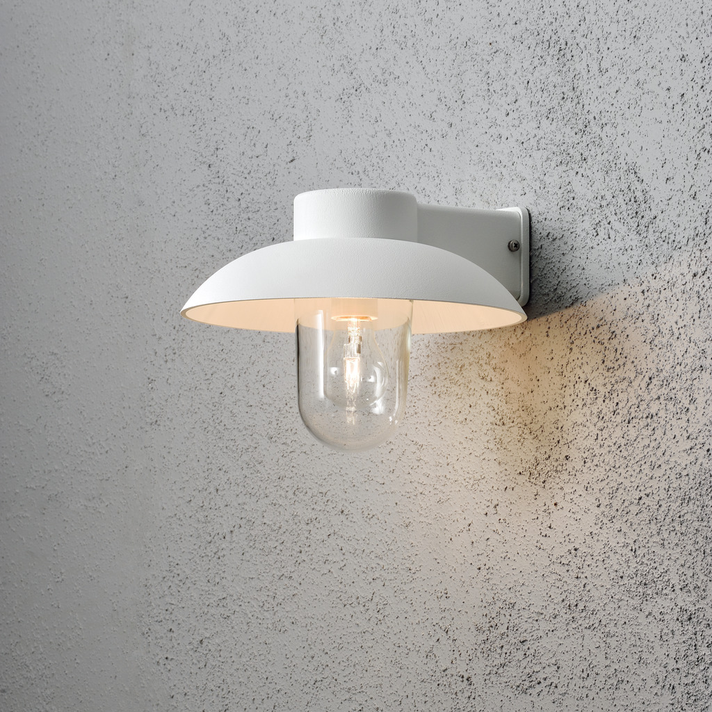 Mani Hvit utendørslampe Fra Konstsmide - Den brede skjermen og den klare glasskuppelen sprer et behagelig og rettet lys, noe som gjør lampen perfekt for entre og uteplasser.
