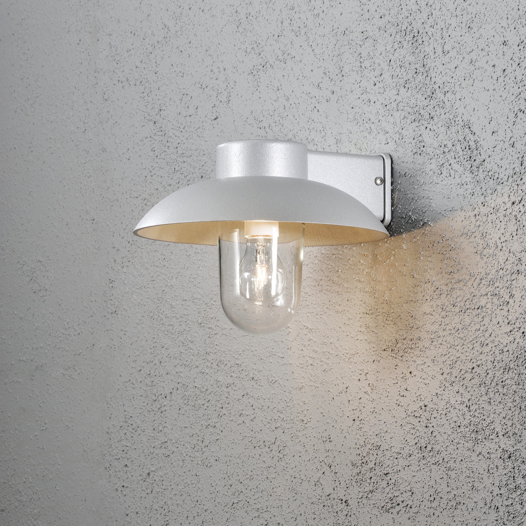 Mani Grå utendørslampe Fra Konstsmide - Den brede skjermen og den klare glasskuppelen sprer et behagelig og rettet lys, noe som gjør lampen perfekt for entre og uteplasser.