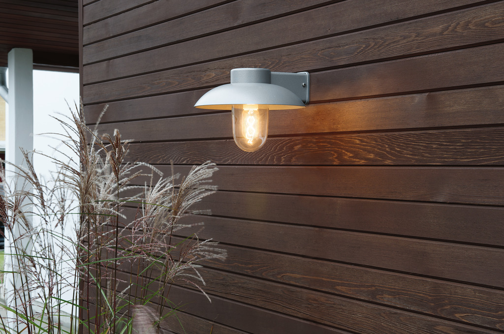 Mani Grå utendørslampe Fra Konstsmide - Den brede skjermen og den klare glasskuppelen sprer et behagelig og rettet lys, noe som gjør lampen perfekt for entre og uteplasser.