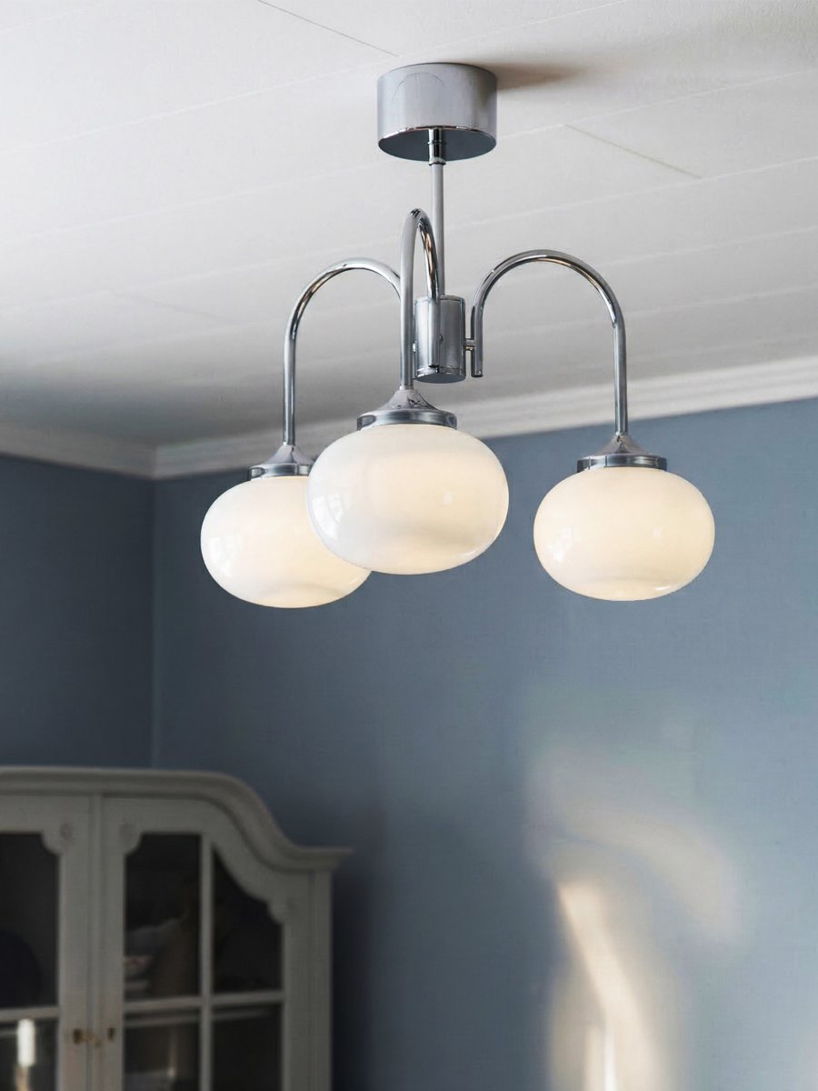 Elsy Ø52 Krom plafond Fra PR Home - Lampen har tre nedadrettede armer med hvite glaskupler som sprer en myk og behagelig gl&oslash;d, og skaper en koselig atmosf&aelig;re i for eksempel stuen, spisestuen eller gangen.