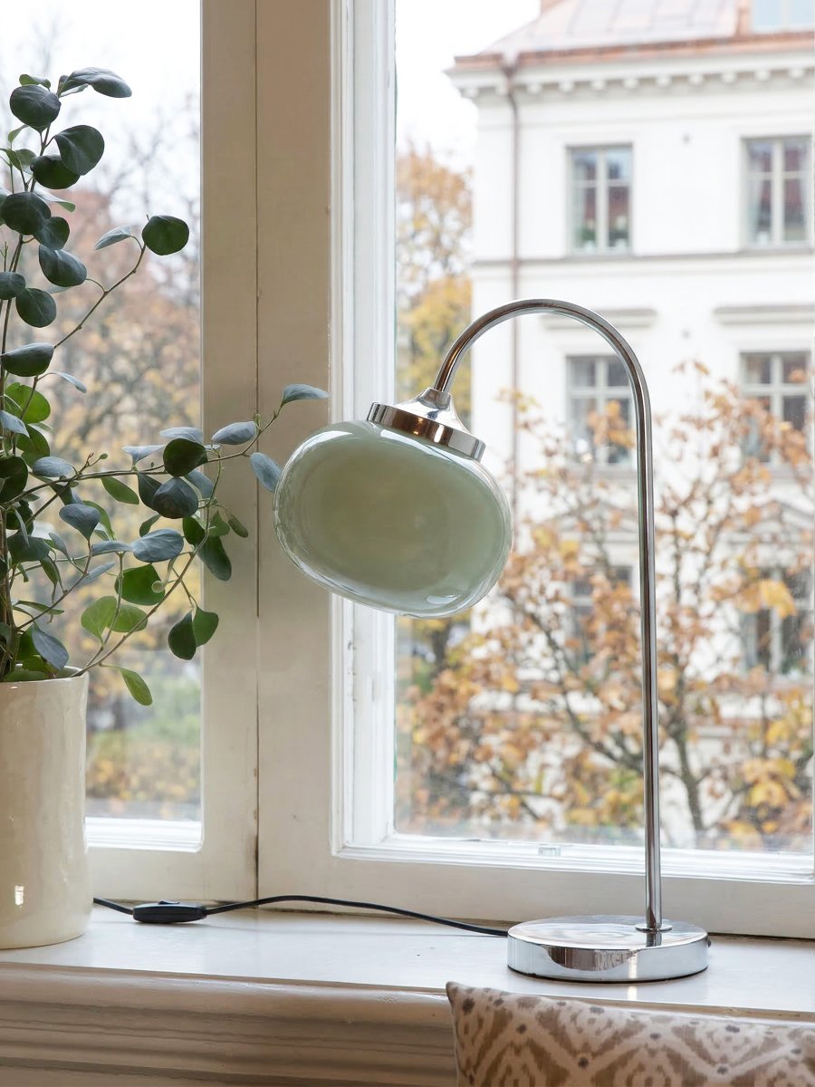 Elsy 50cm Grønn bordlampe Fra PR Home - Den h&aring;ndlagde glassskjermen i en myk salviegr&oslash;nn farge gir hver lampe en unik karakter, mens de forkrommede metalldetaljene skaper en stilig og tidl&oslash;s helhet.
