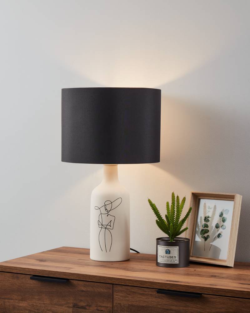 Vinoza 53cm Hvit bordlampe Fra Eglo - Med en hvit base dekorert med minimalistiske linjer som representerer en kvinne i en hatt, gir lampen et sofistikert og kunstnerisk preg til hjemmet ditt.