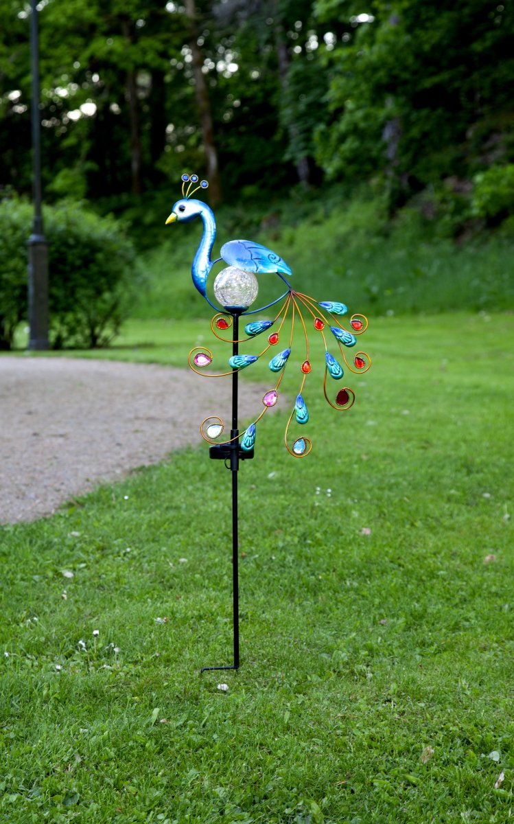 Peacock Flerbruk solcellelampe Fra Star Trading - Den integrerte glasskulen skinner med en varm hvit glød om natten og skaper en koselig og dekorativ atmosfære.