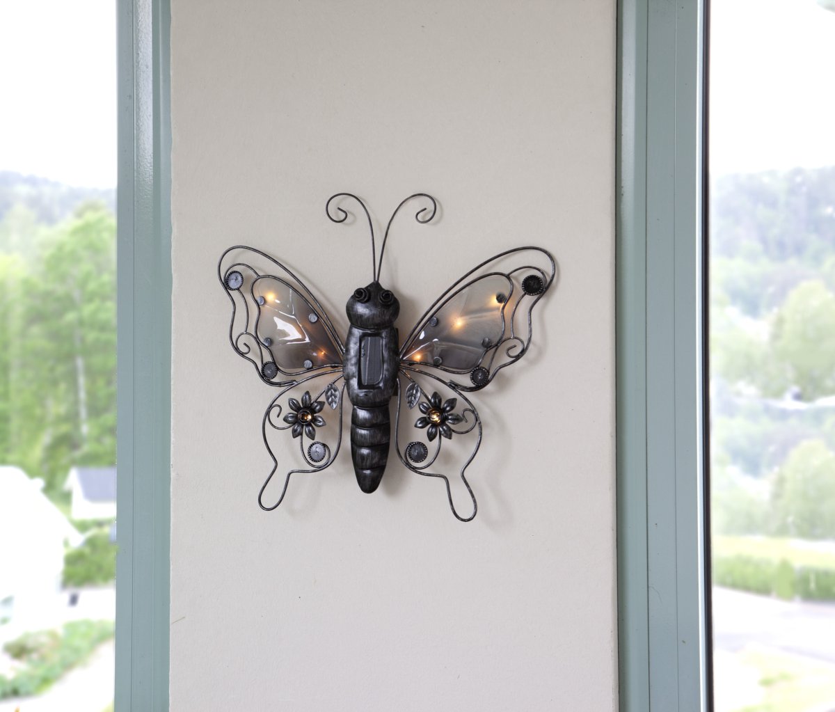 Butterfly Svart solcellelampe Fra Star Trading - Laget av svart metall blir den et stilig innslag på en fasade, et gjerde eller en balkong.