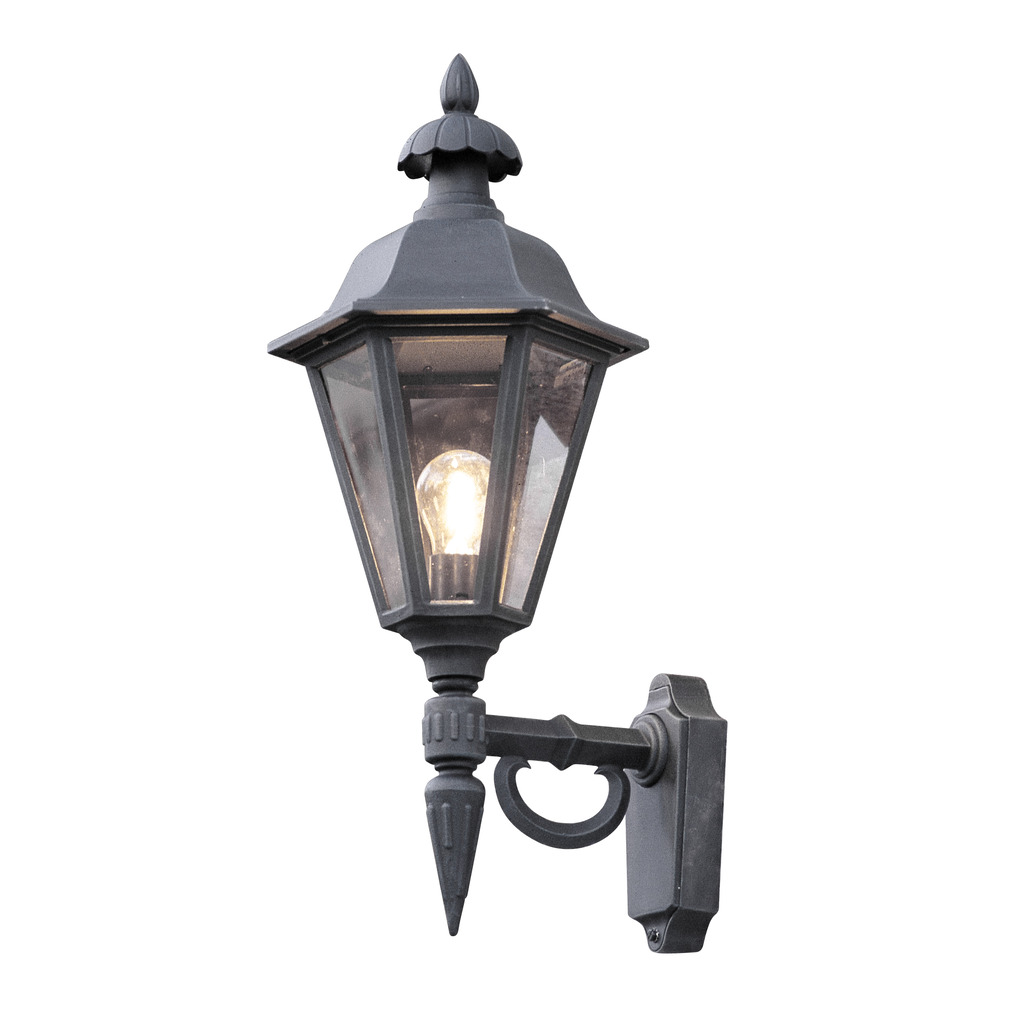 Pallas Svart utendørslampe Fra Konstsmide - Med sitt lanterneformede design og klare glassfelt sprer lampen et varmt og innbydende lys som er perfekt for innganger, uteplasser og gangveier.