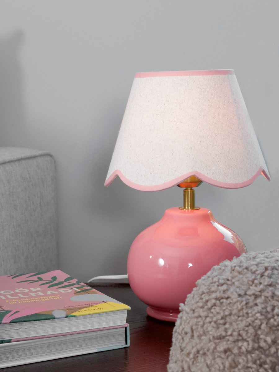 Nell 34cm Rosa bordlampe Fra PR Home - Den sf&aelig;riske lampefoten i blank, rosa er kombinert med en beige tekstilskjerm som gir et mykt og harmonisk uttrykk, perfekt for b&aring;de soverom og stuer.