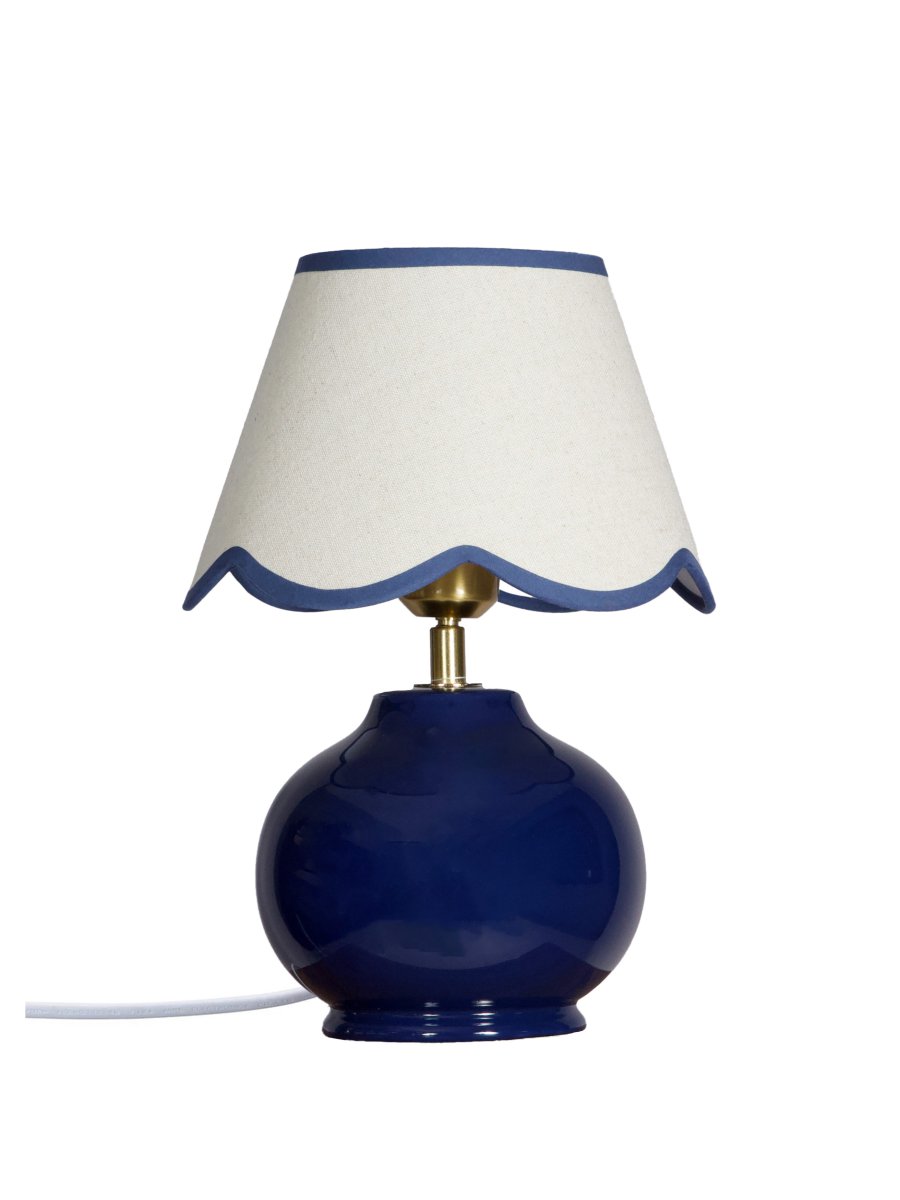 Nell 34cm Blå bordlampe Fra PR Home - Den sf&aelig;riske lampefoten i en blank, dyp bl&aring; farge er kombinert med en beige tekstilskjerm som gir et mykt og harmonisk uttrykk, perfekt for b&aring;de soverom og stuer.