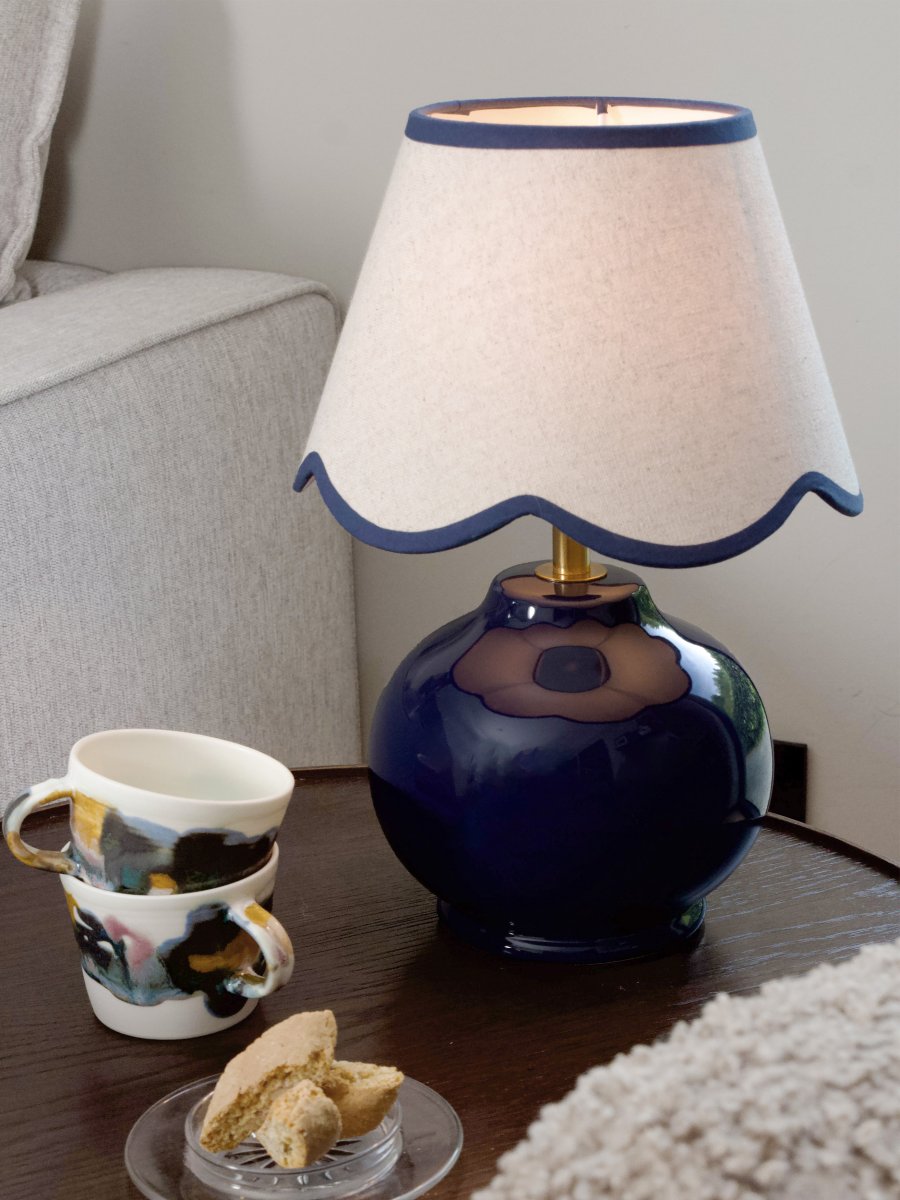 Nell 34cm Blå bordlampe Fra PR Home - Den sf&aelig;riske lampefoten i en blank, dyp bl&aring; farge er kombinert med en beige tekstilskjerm som gir et mykt og harmonisk uttrykk, perfekt for b&aring;de soverom og stuer.