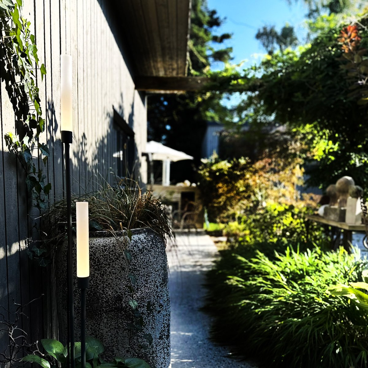 Frost Mørk grå Fra Lightson - Frost &auml;r ett elegant set av tv&aring; ljuspelare i m&ouml;rkgr&aring; aluminium som f&ouml;rvandlar dina utomhusmilj&ouml;er med sitt varma, mjuka ljus.