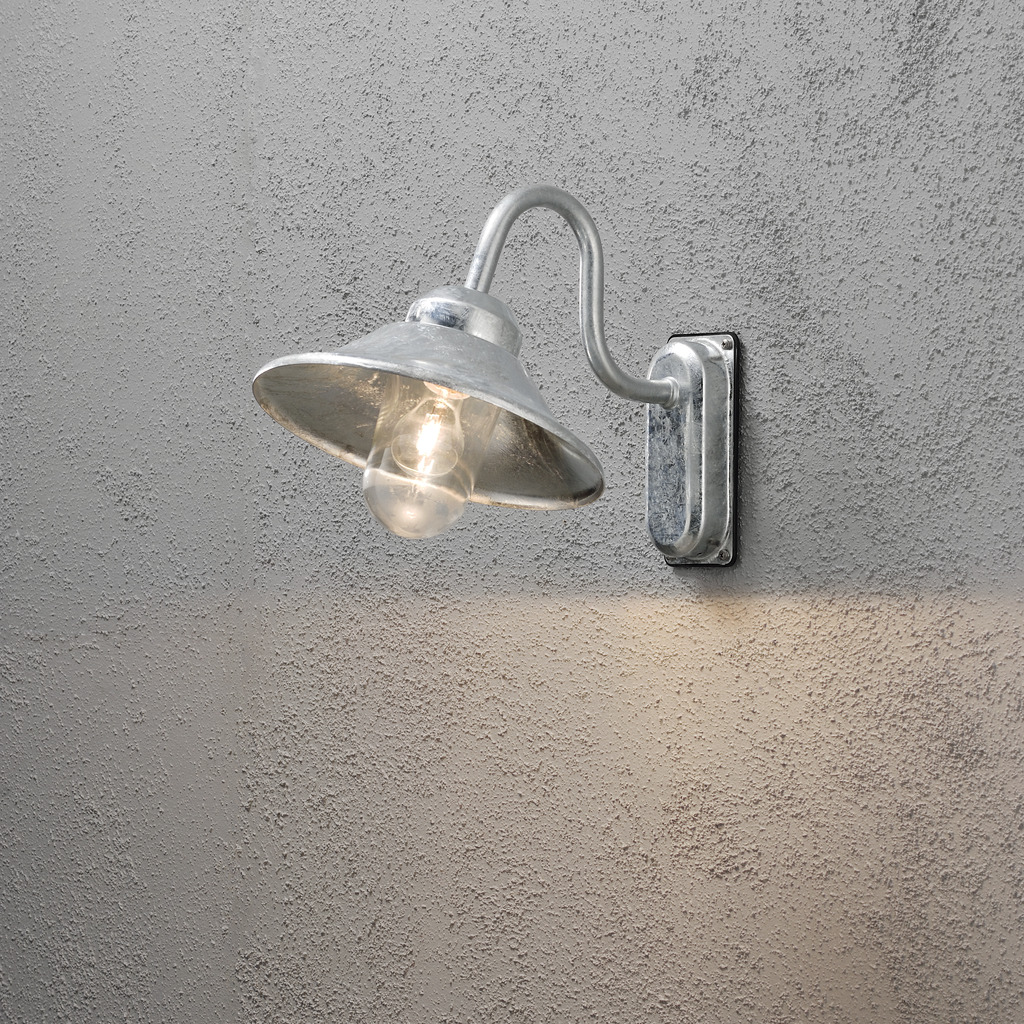 Vega Galvanisert stål utendørslampe Fra Konstsmide - Med sin klassiske form og store skygge skaper den et behagelig og rettet lys, perfekt for entréer og uteplasser.