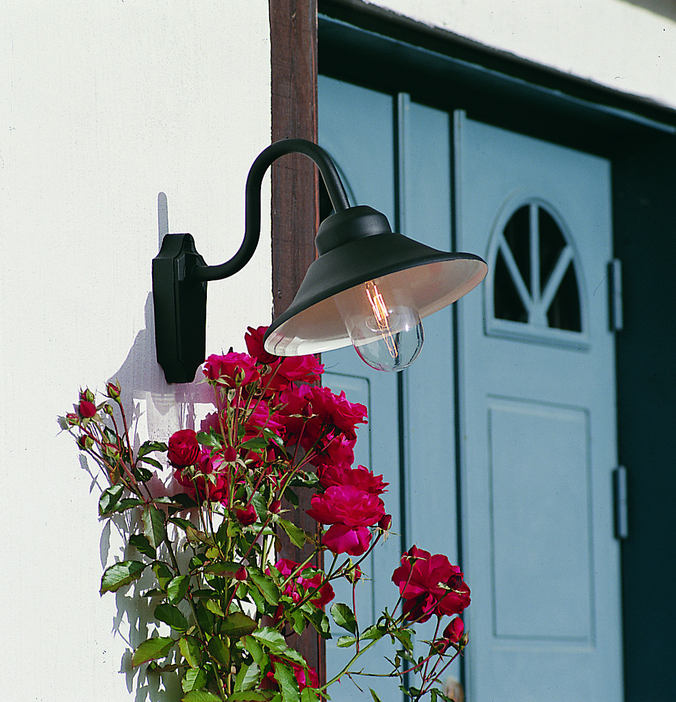 Vega Svart utendørslampe Fra Konstsmide - Med sin klassiske form og store skygge skaper den et behagelig og rettet lys, perfekt for entréer og uteplasser.