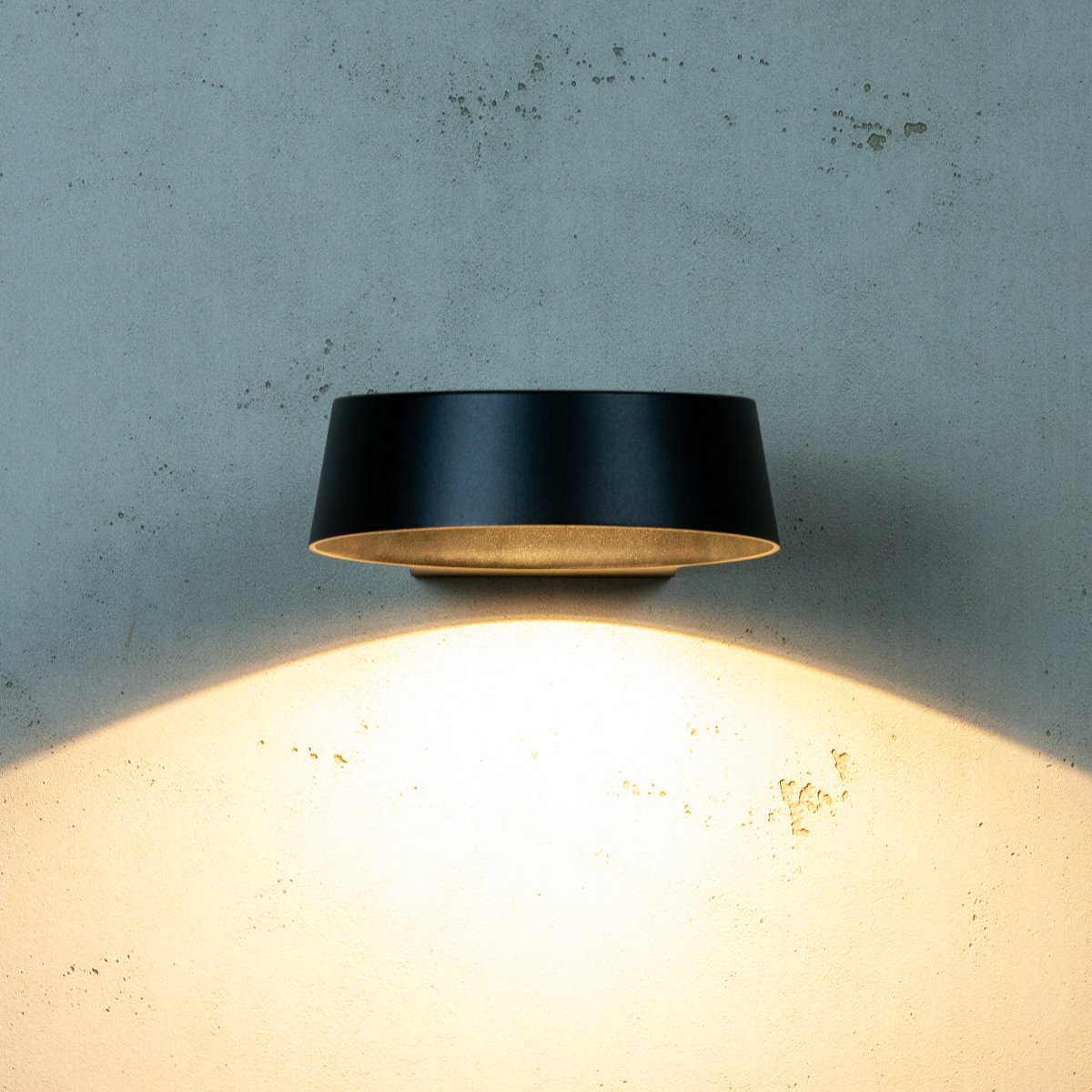 Neptun Svart utendørslampe Fra Dyberg Larsen - Med sin runde form sprer den et stort lysfelt som gj&oslash;r at den passer fint p&aring;; alle typer vegger.