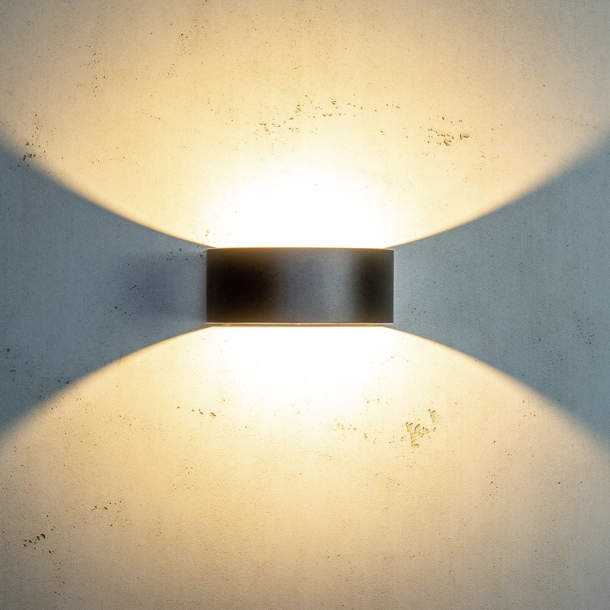 Circle Svart utendørslampe Fra Dyberg Larsen - Lampens sirkulære design har en flat bakside mot veggen og en halvsirkelformet front, hvor en LED-lyssløyfe sprer et vakkert vertikalt lys opp og ned på veggen.