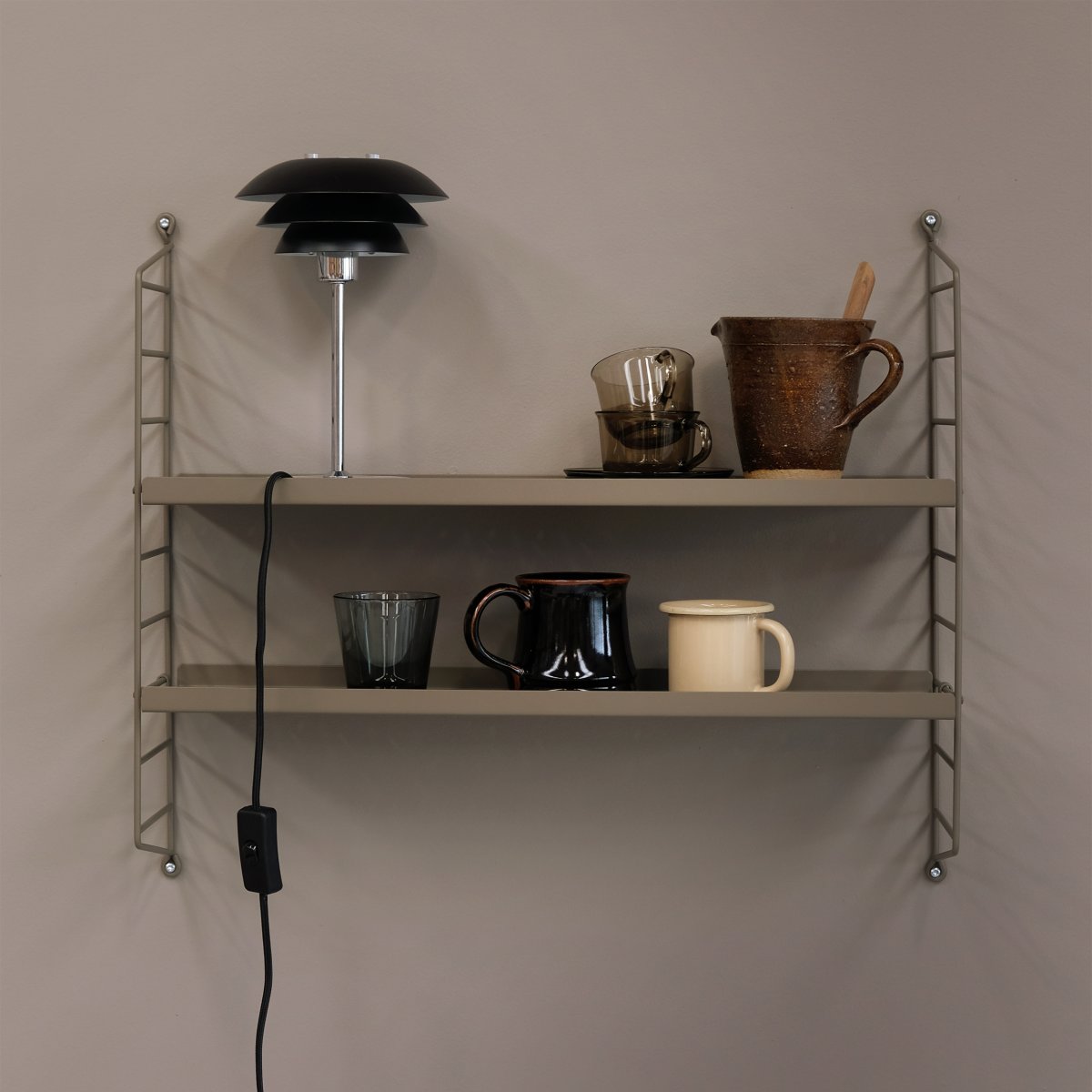 DL16 25cm Svart bordlampe Fra Dyberg Larsen - Skjermene er laget av metall og basen i krom, med fargealternativene sort og hvit.