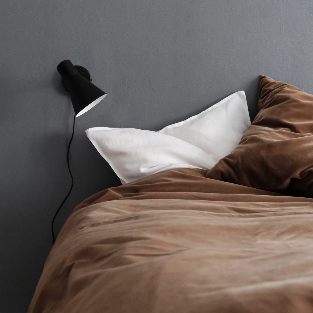 DL12 Svart leselampe Fra Dyberg Larsen - Med sin moderne, matt sorte design og vinklede skjerm gir DL12 et fokusert og behagelig lys, ideelt for studier eller som nattbordslampe.