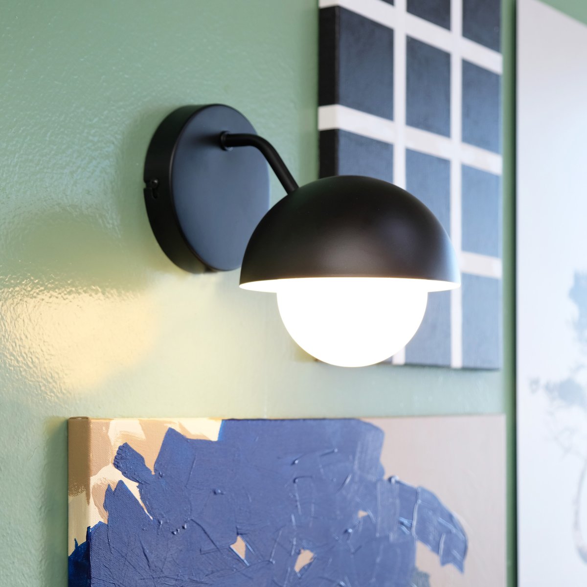 Rose Ø15 Matt svart vegglampe Fra Dyberg Larsen - Glasskuppelen fungerer som en naturlig lysspreder og skaper en varm og innbydende atmosfære i rommet.