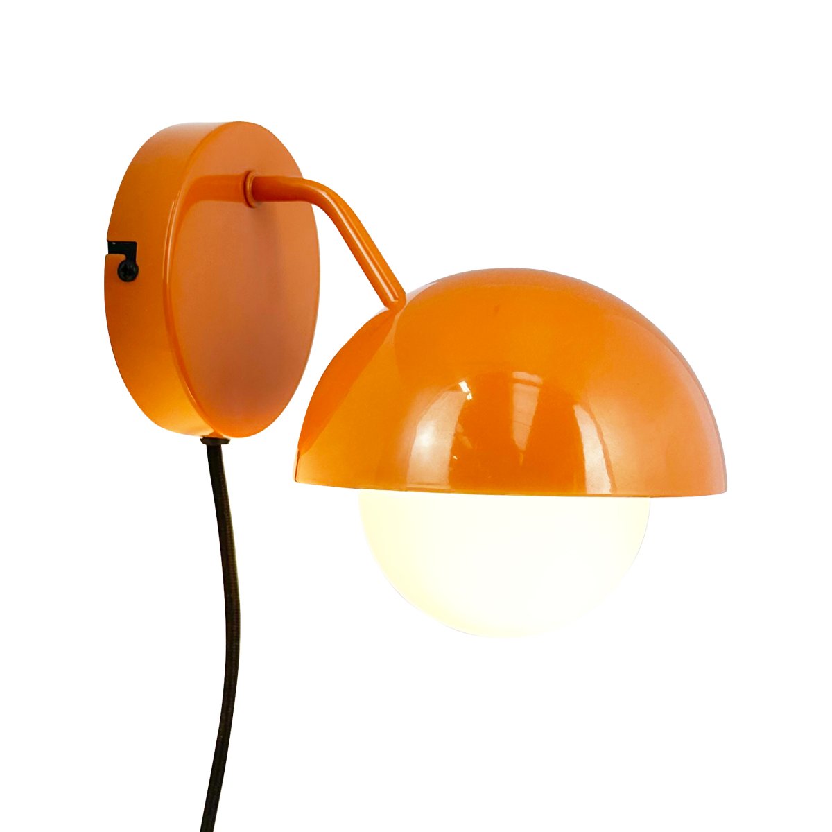 Rose Ø15 skinnende oransje vegglampe Fra Dyberg Larsen - Glasskuppelen fungerer som en naturlig lysspreder og skaper en varm og innbydende atmosfære i rommet.
