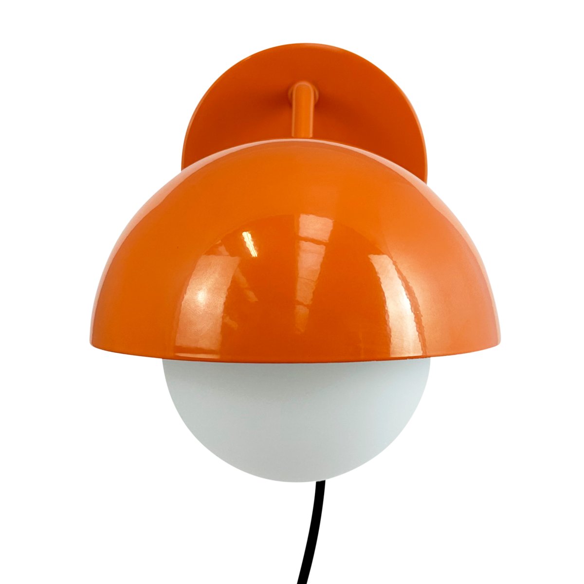 Rose Ø15 skinnende oransje vegglampe Fra Dyberg Larsen - Glasskuppelen fungerer som en naturlig lysspreder og skaper en varm og innbydende atmosfære i rommet.