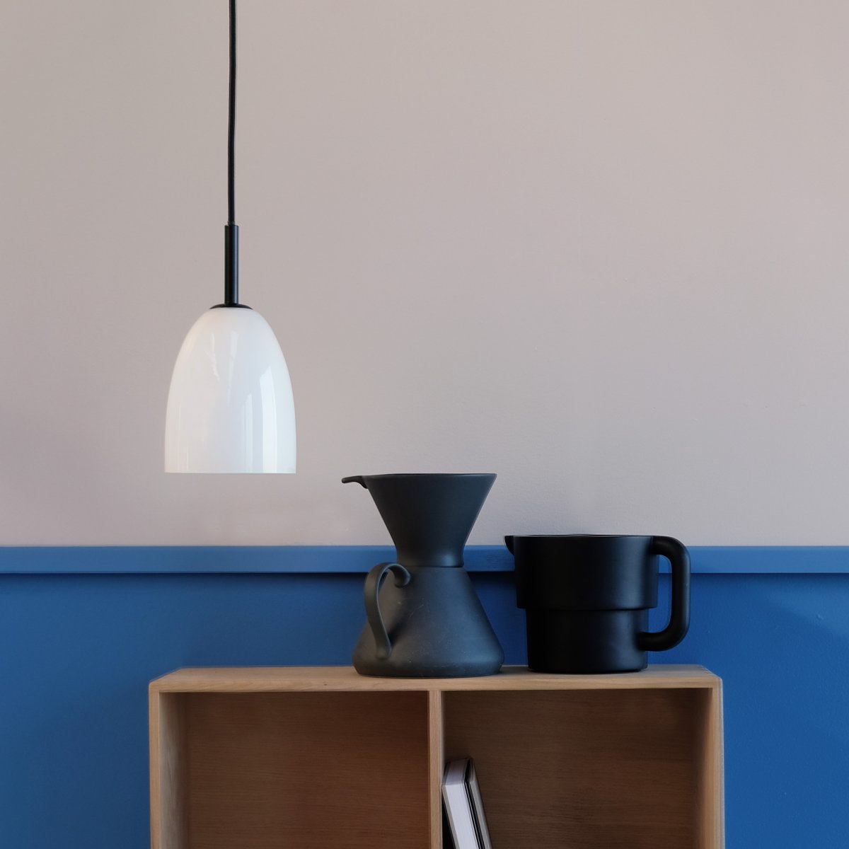 Jazz Ø12 Svart Taklampe Fra Dyberg Larsen - Jazz pendellampe i opalhvitt glass kombinerer en moderne glassskjerm med minimalistisk svart oppheng, og gir et sofistikert preg til ethvert interiør.