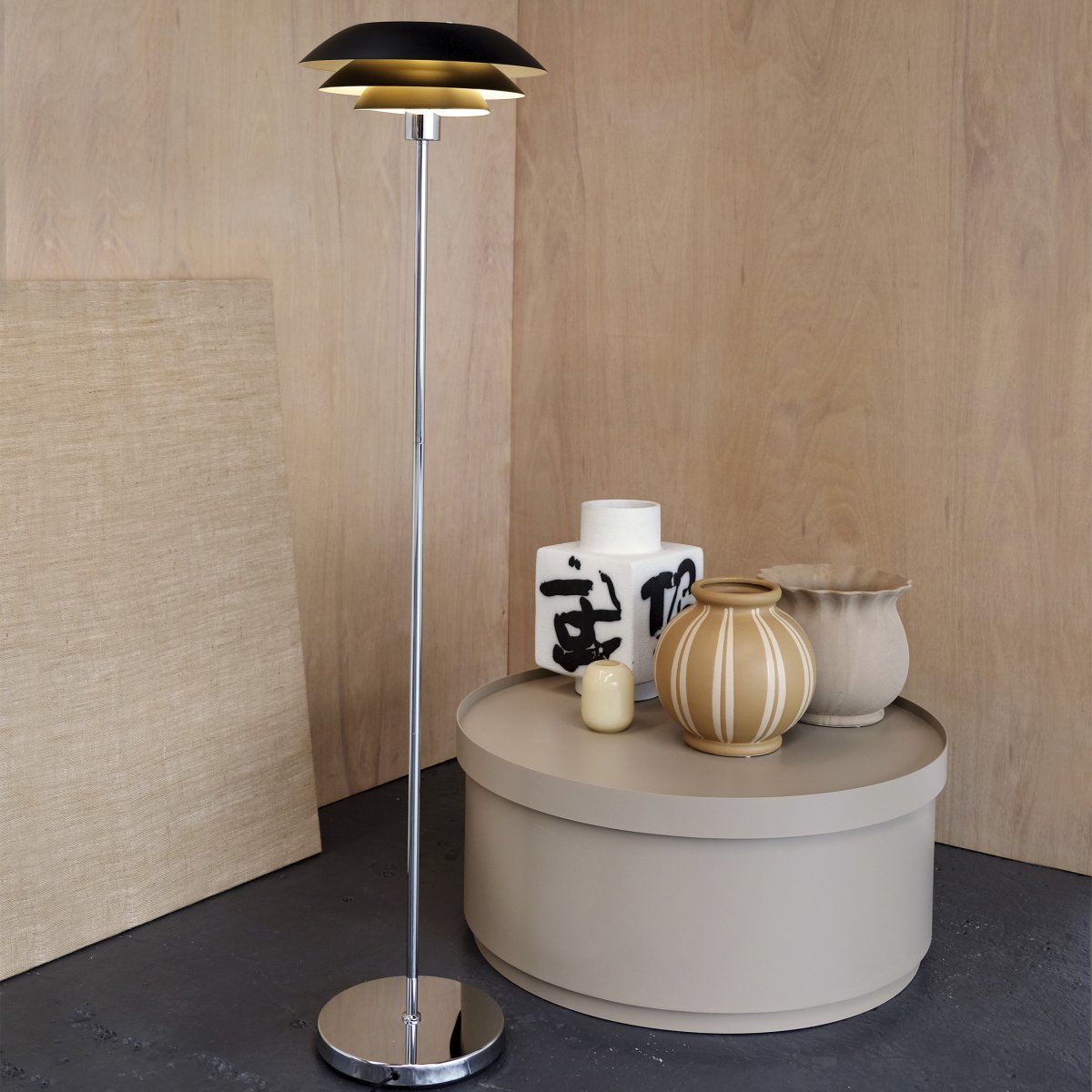 DL31 Svart gulvlampe Fra Dyberg Larsen - Gulvlampen er klassisk og dramatisk i sort i kombinasjon med forkrommet metall, perfekt for et m&oslash;rkt hj&oslash;rne av hjemmet, ved siden av sofaen eller som en elegant interi&oslash;rdetalj i seg selv.