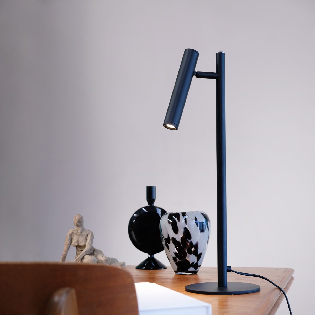 Carlo 48cm Svart skrivebordslampe Fra Dyberg Larsen - Den har innebygget LED og en trinnløs dimmer som styres med en berøringsknapp.
