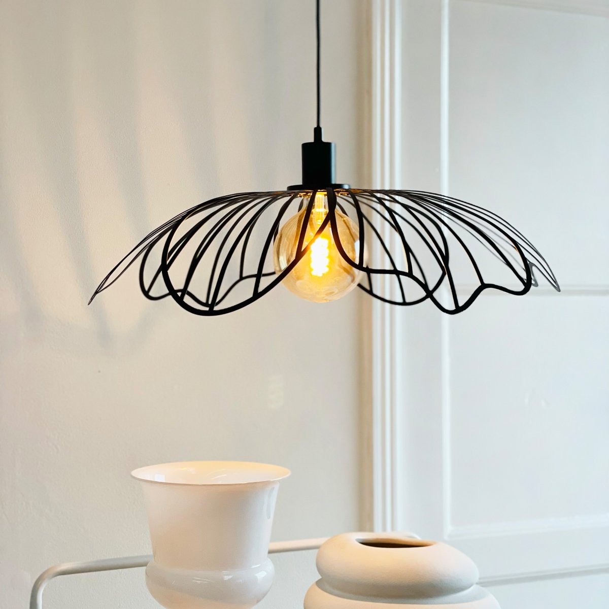 Blumen Ø60 Matt svart Taklampe Fra Dyberg Larsen - Den sprider ett sofistikerat ljus och fungerar som en unik mittpunkt i hemmet, vare sig den h&auml;nger &ouml;ver matbordet, i vardagsrummet eller i entr&eacute;n.