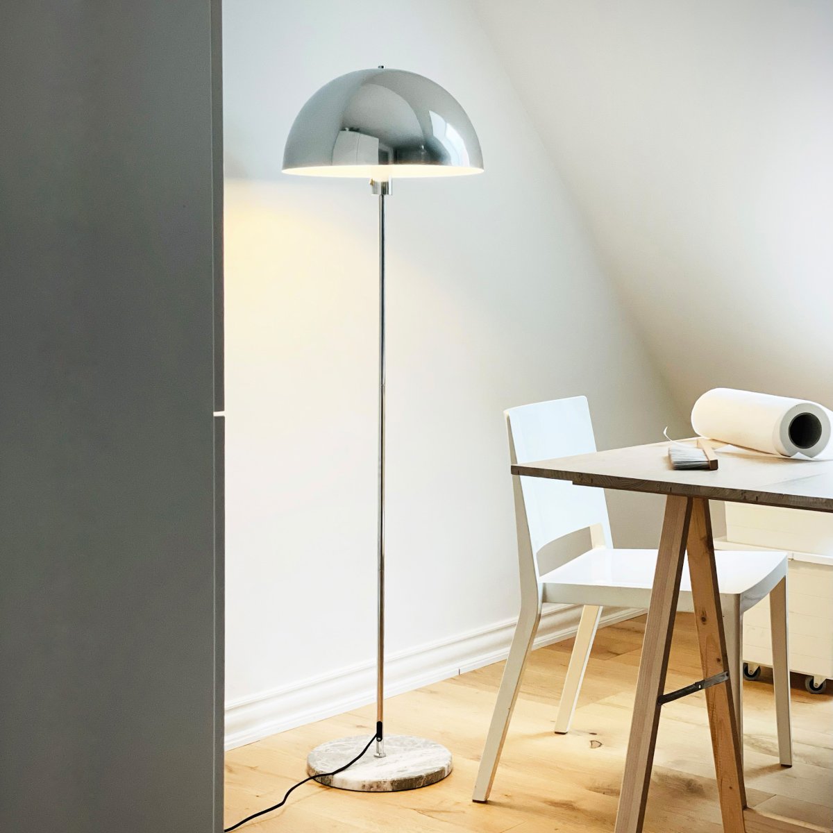 Stockholm Krom gulvlampe Fra Dyberg Larsen - Den solida marmorfoten ger lampan ett exklusivt och tidl&ouml;st uttryck, medan den smala kromramen tillf&ouml;r en l&auml;tt och stilren touch.