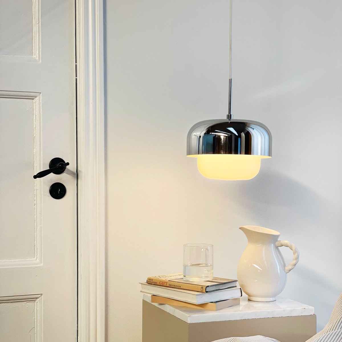 Haipot Ø23 Krom Taklampe Fra Dyberg Larsen - Det stilige designet kombinerer en &oslash;vre metallskjerm med kromfinish og en nedre del i hvitt glass som sprer et jevnt og behagelig lys.