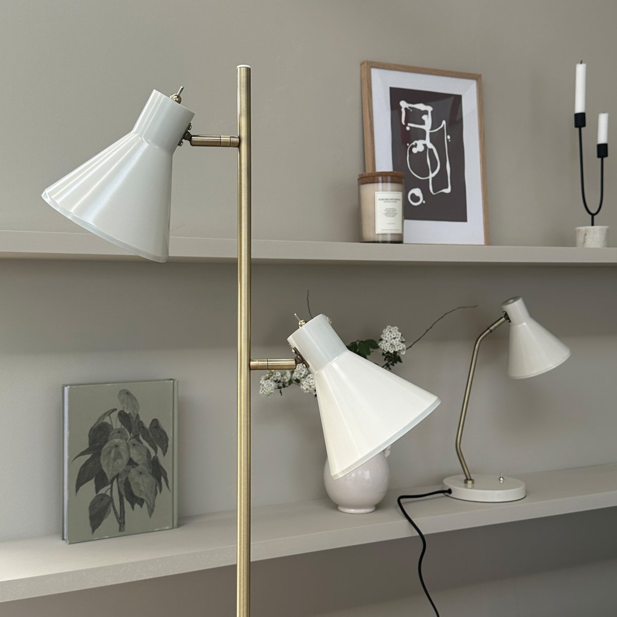 Sleep Skinnende hvit gulvlampe Fra Dyberg Larsen - Den hvite fargen gir lampen et moderne og rent utseende som passer inn i ulike interi&oslash;rstiler, mens detaljene i antikk messing gir et elegant preg.