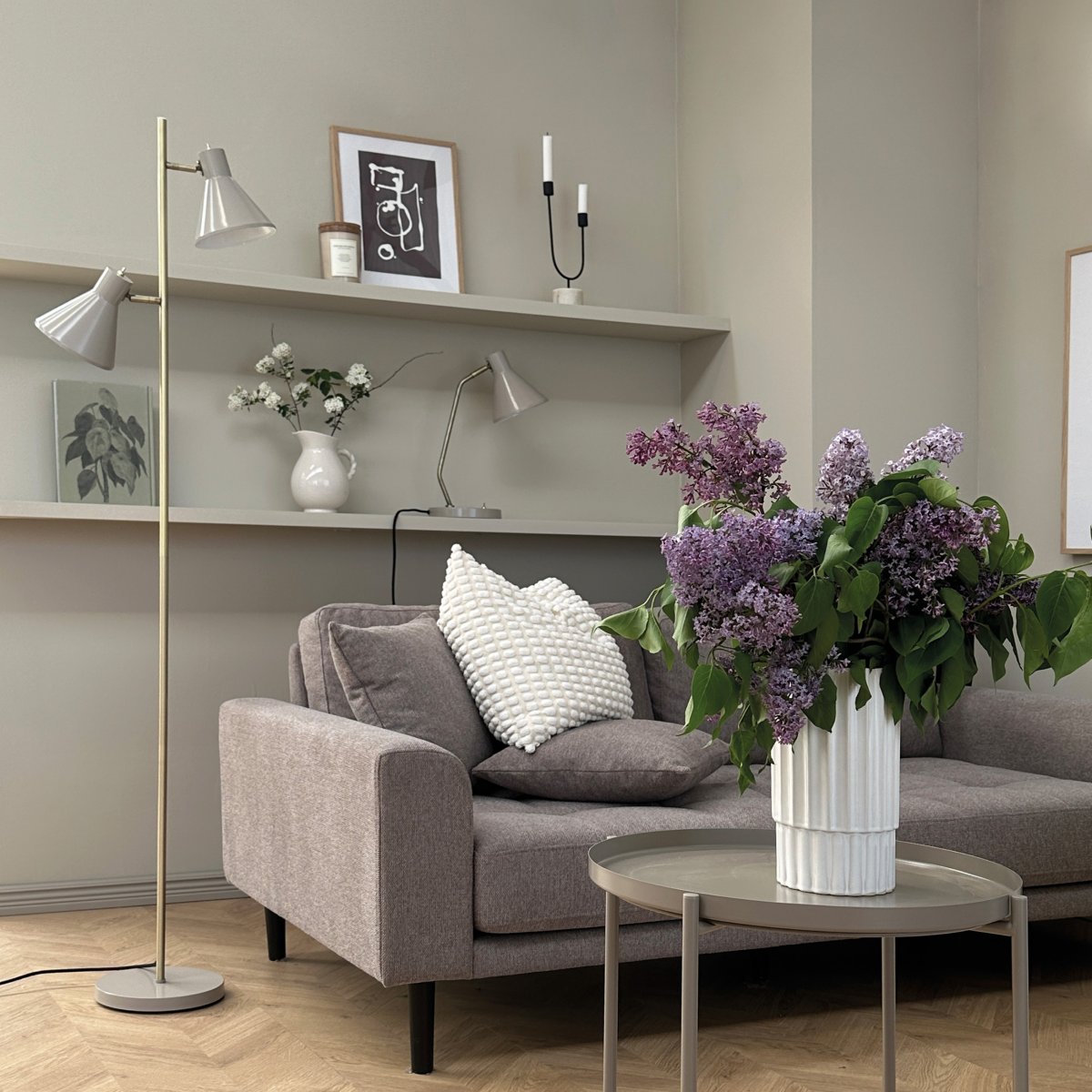 Sleep Skinnende beige gulvlampe Fra Dyberg Larsen - Fargen beige gir lampen et moderne og rent utseende som passer inn i ulike interi&oslash;rstiler, mens detaljene i antikk messing gir et elegant preg.
