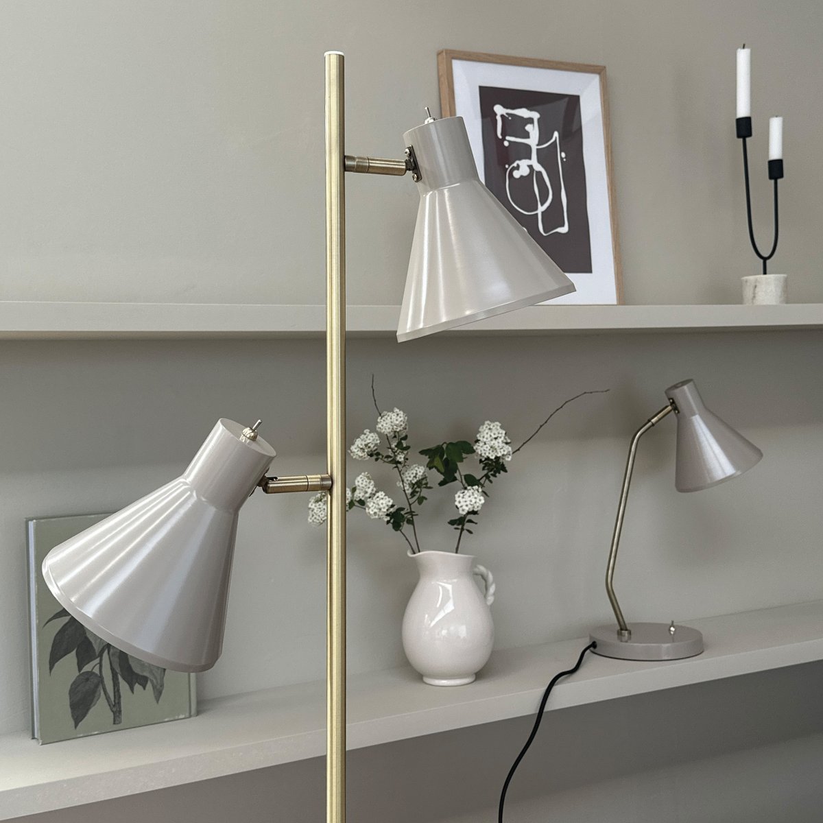 Sleep Skinnende beige gulvlampe Fra Dyberg Larsen - Fargen beige gir lampen et moderne og rent utseende som passer inn i ulike interi&oslash;rstiler, mens detaljene i antikk messing gir et elegant preg.