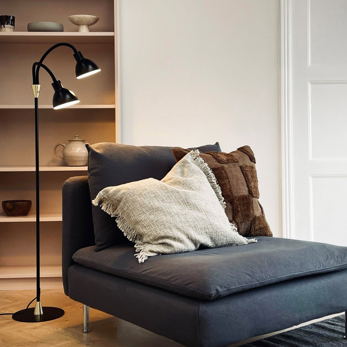 Lilje Svart gulvlampe Fra Dyberg Larsen - Lily golvlampa i svart och m&auml;ssing kombinerar modern design med flexibilitet och funktionalitet.