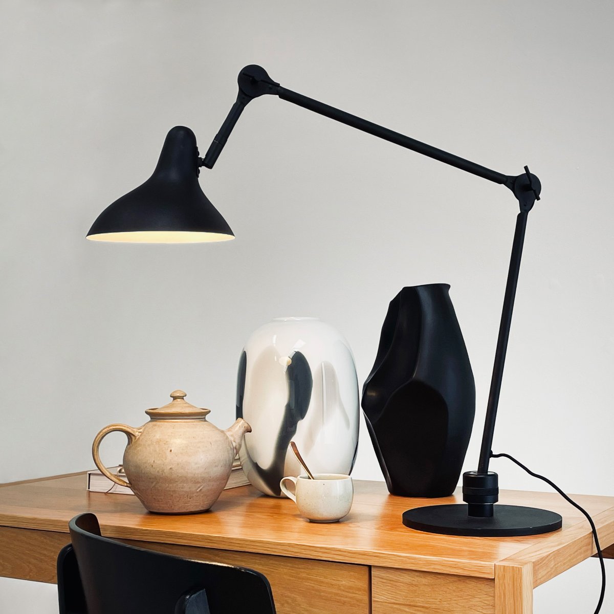 Lotus 85cm Svart skrivebordslampe Fra Dyberg Larsen - Med sin fleksible arm og justerbare skjerm kan du enkelt justere lyset etter behov, noe som gjør det perfekt for arbeidsområder eller klasserom.