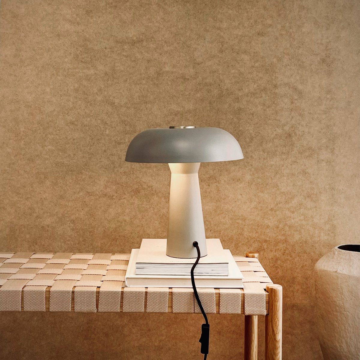 Iris 28cm Grå bordlampe Fra Dyberg Larsen - Den soppformede lampeskjermen i myk gr&aring;; tone har en subtil messingdetalj p&aring; toppen som gir et luksuri&oslash;st preg.